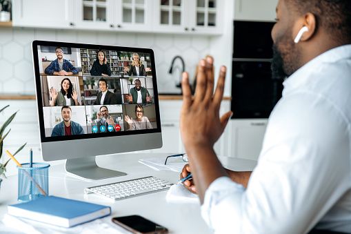 PC med videomøte og en mann som deltar og vinker